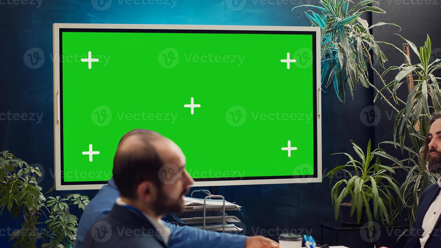 Marketing team meeting in a boardroom with isolated TV display, working together to improve the organization public image and social media presence. Business specialists conduct analysis. Camera A. photo
