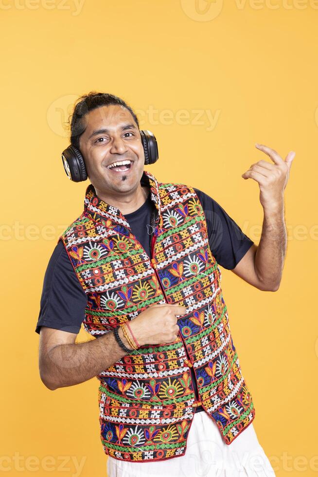 Portrait of rocker delighted to play rock music with air guitar, isolated over studio backdrop. Overjoyed man pretending to use musical instrument, having fun doing concert photo