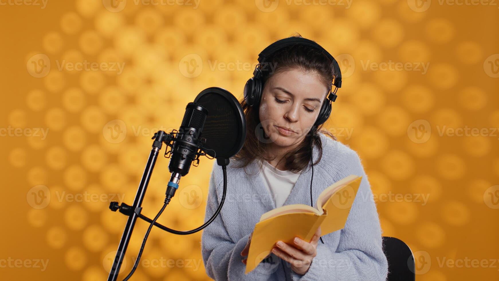 Lady browsing pages, doing voiceover reading of book to produce audiobook. Voice actor preparing to use storytelling skills to entertain audience while recording novel, studio background, camera B photo
