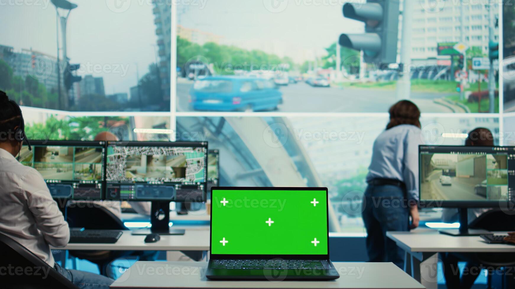 A laptop running isolated mockup display in a monitoring room, people working with surveillance footage from CCTV security cameras around the city. Greenscreen in a government agency. Camera B. photo