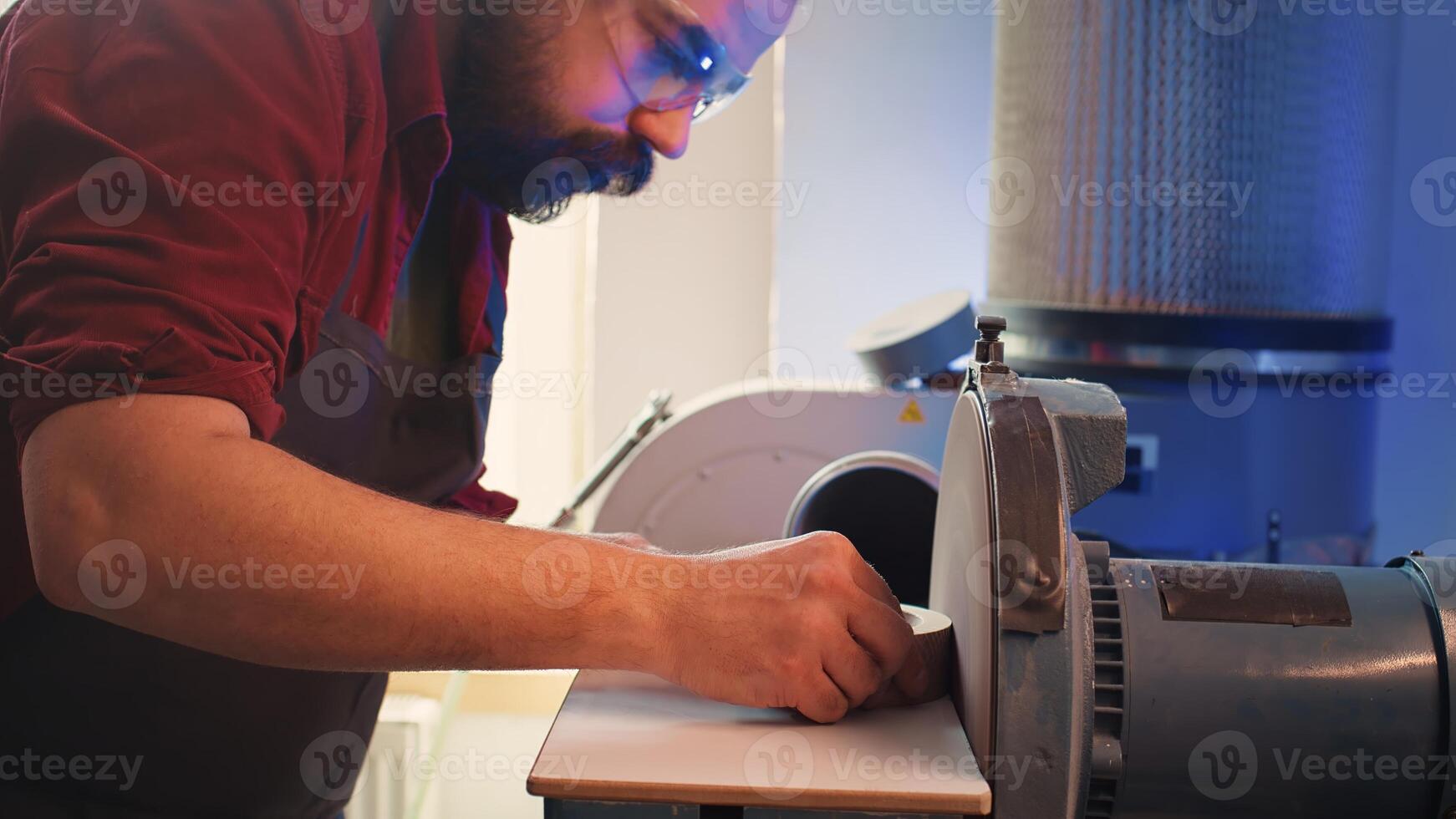 Woodworker shaping wooden bowl on disc sander in carpentry shop, showcasing precision. Cabinetmaker working in joinery, guiding wood against grinding machine rotating disc, camera B close up photo