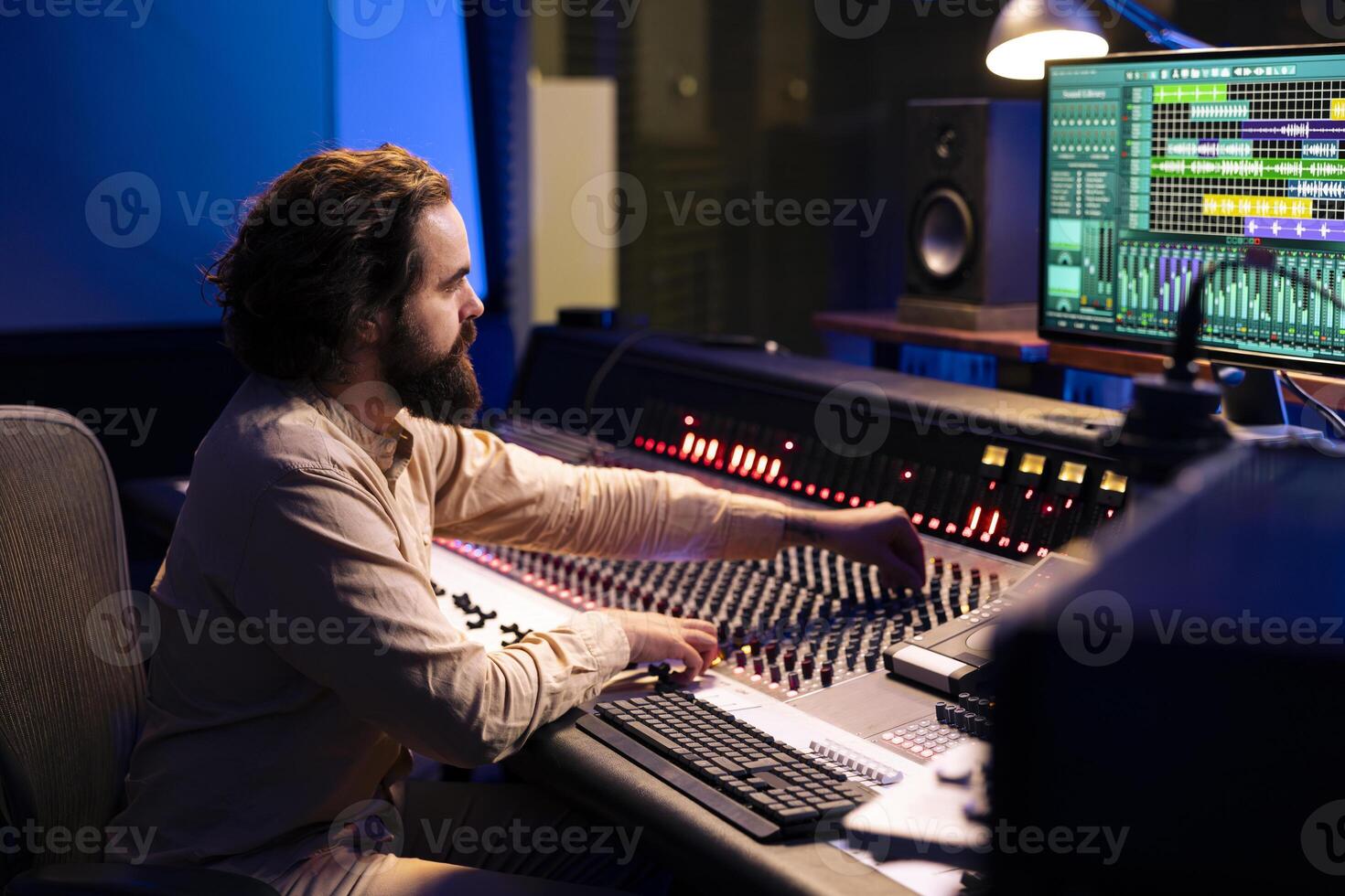 Mixing engineer working on blending individual tunes of a recording to create song for a new album, audio editing pc software in control room. Producer deals with technical aspects of sound. photo