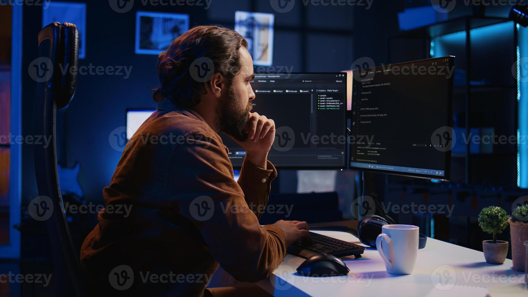 Programmer doing web development during remote job shift in neon lit home office, finishing coding project. IT specialist sitting at computer desk, working on desktop PC, camera B photo