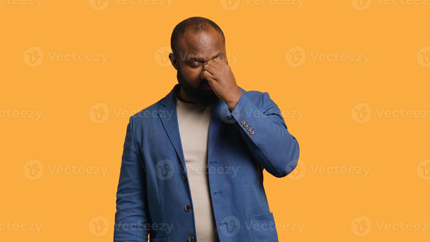 African american man feeling exhausted from overworking and lack of sleep, suffering from headache and yawning, studio background. Tired BIPOC person feeling migraine from fatigue, camera A photo