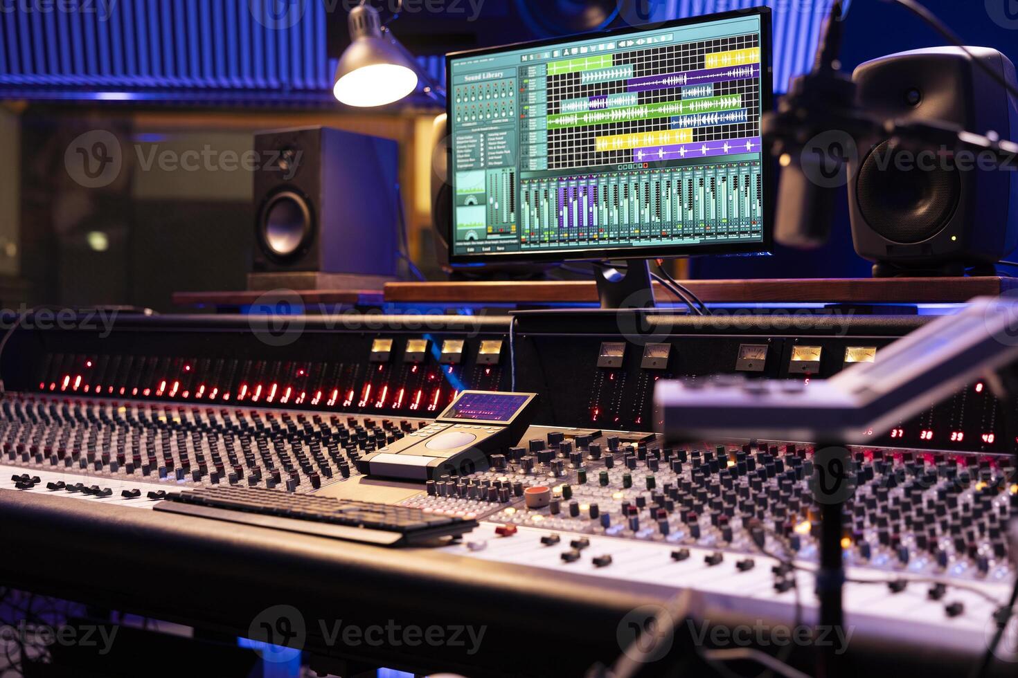 Control desk in professional music studio with motorized faders and knobs used in mixing and mastering tracks. Empty control room used in recording and producing songs, sound booth. photo