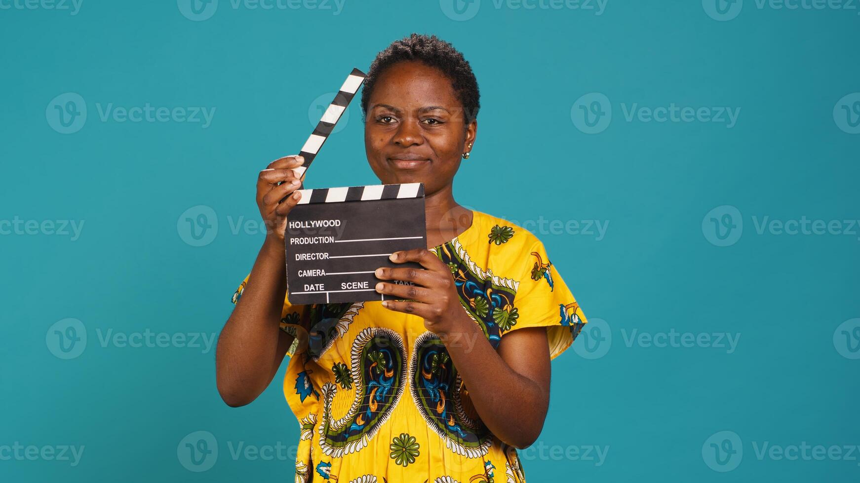 Female film producer using a clapperboard to say action in movie industry and cinematography. Skilled filmmaker woman cutting a scene with filming slate, production. Camera A. photo