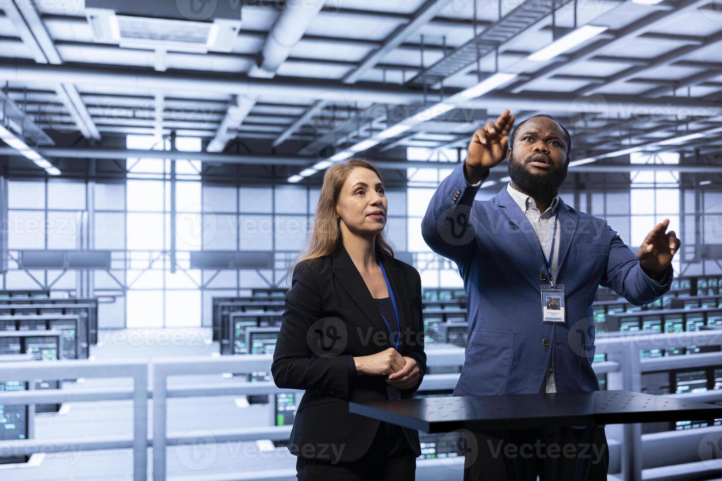 Coworkers using AR in data center, ensuring cybersecurity and efficient network management. Engineers in server hub optimizing data center equipment with augmented reality technology photo