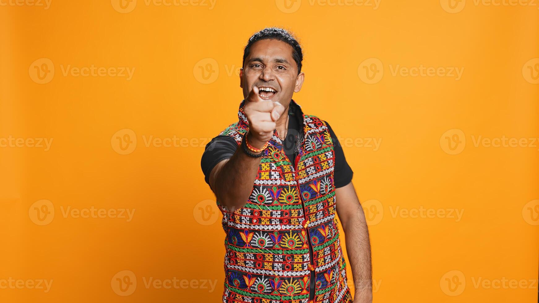Portrait of narcissistic cheerful indian man celebrating and bragging, showing arrogance. Satisfied person boasting about achievement, cheering and gesticulating, studio background, camera B photo