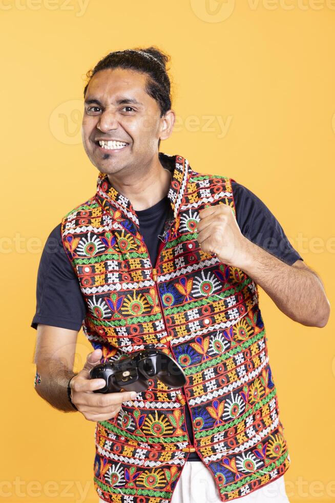 Joyous gamer celebrating achievement after winning game on gaming console, having fun. Ecstatic man feeling excited after being victorious in videogame using joypad, defeating all enemies photo