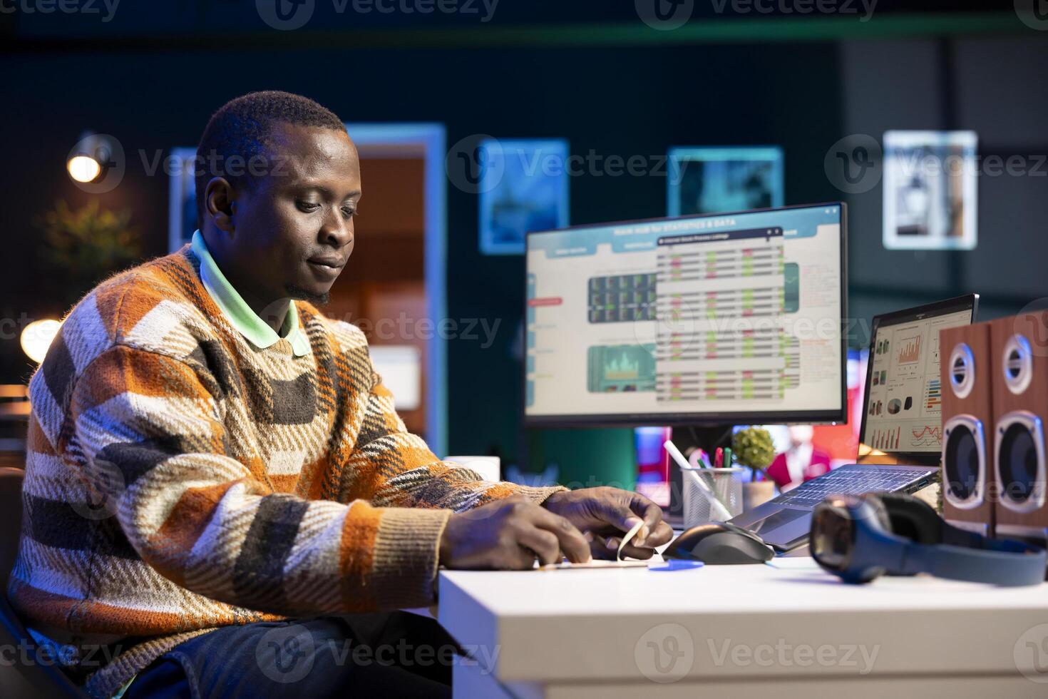 Financial advisor writing a posit it memory note to work on revenue balance, studying annual statistics to create a report for his CEO. Black accountant evaluating legal infographics. photo
