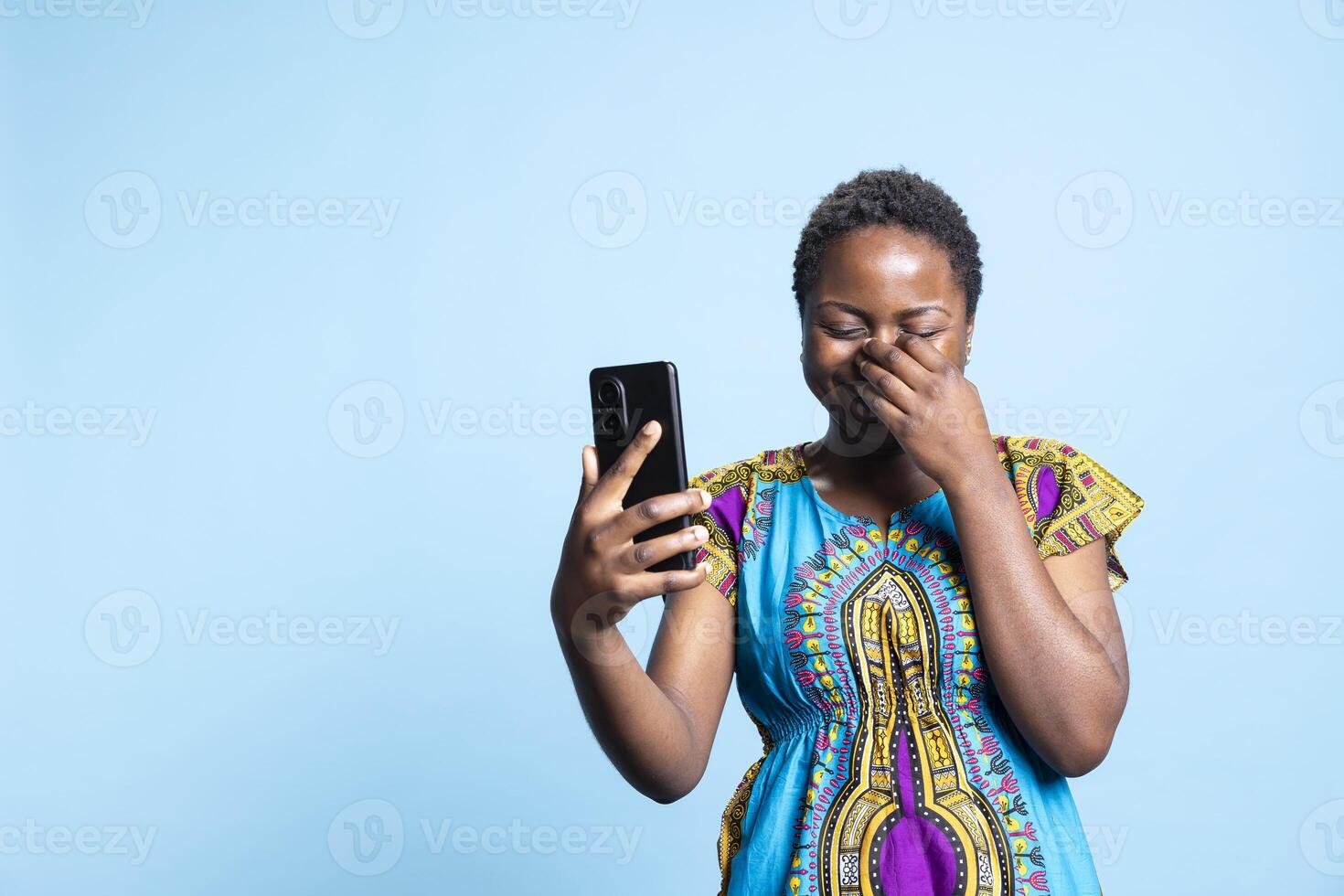 Optimistic pretty person attending videocall online on her smartphone, waving at webcam and talking to friends via internet connection. Woman feeling happy on videoconference meeting. photo