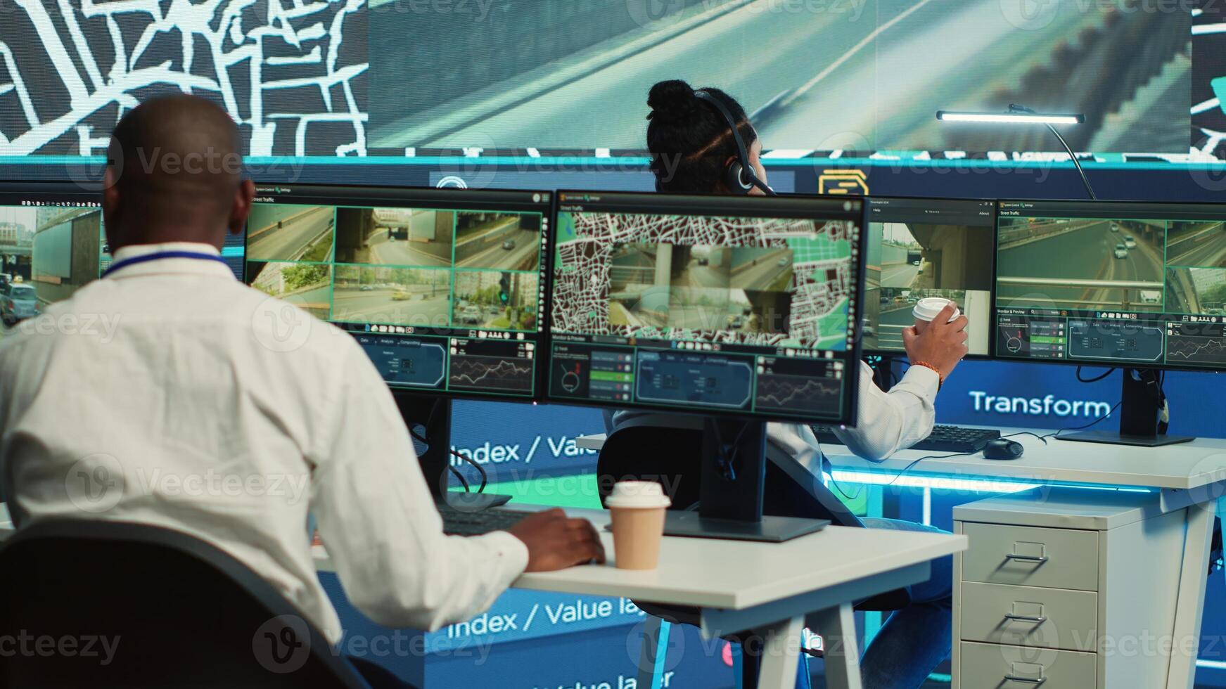 Cargo shipping agency employees operating on city satellite map to communicate the best routes for the colleagues on the field. Operators monitoring their cars and couriers in traffic. Camera A. photo