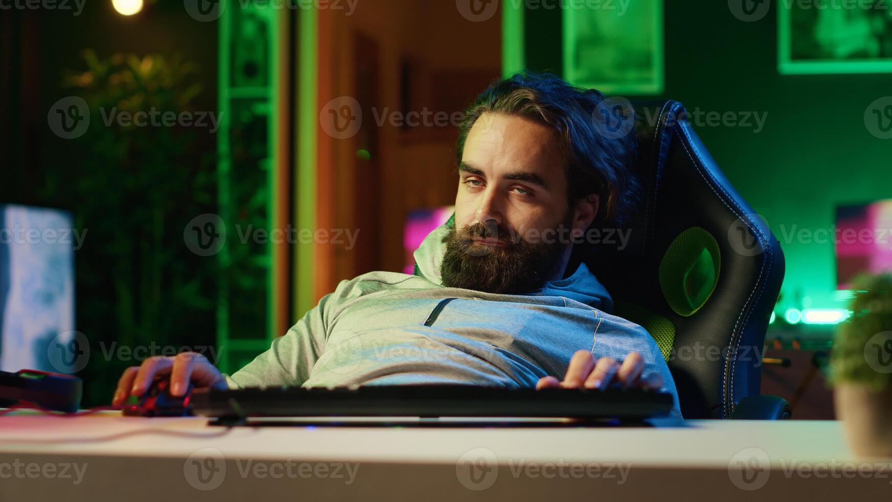 Gamer having seizure while at computer desk, exhausted after pathologically playing videogames all day. Lethargic man falling asleep, crashing with chair from fatigue, suffering from gaming addiction photo
