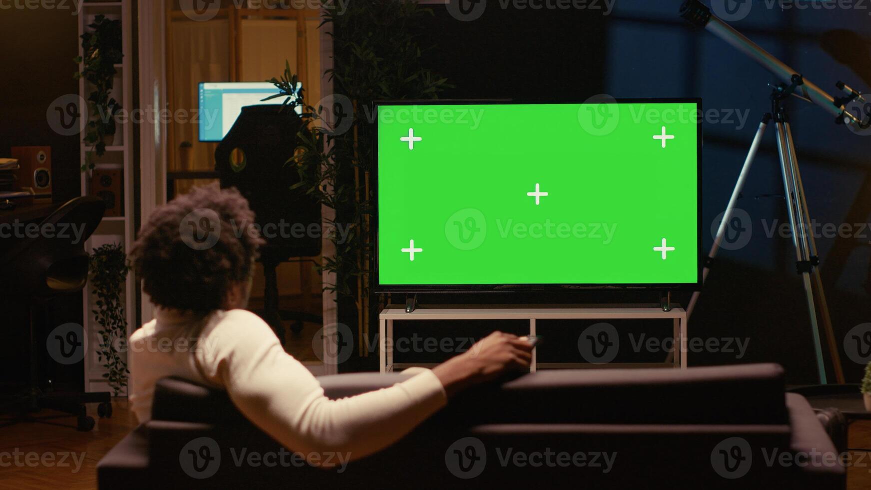 Person using chroma key projector to binge series on subscription based streaming services. Cord cutter relaxing on couch, enjoying on demand shows on mockup smart TV photo