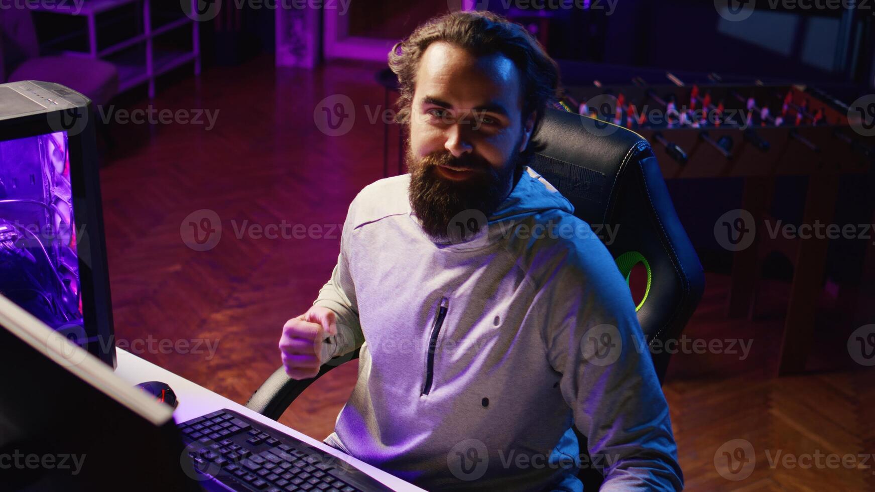 Professional gamer arriving in studio, greeting fans during livestream, talking about gaming systems. Man broadcasting from lit living room, engaging with viewers, discussing videogames topics photo