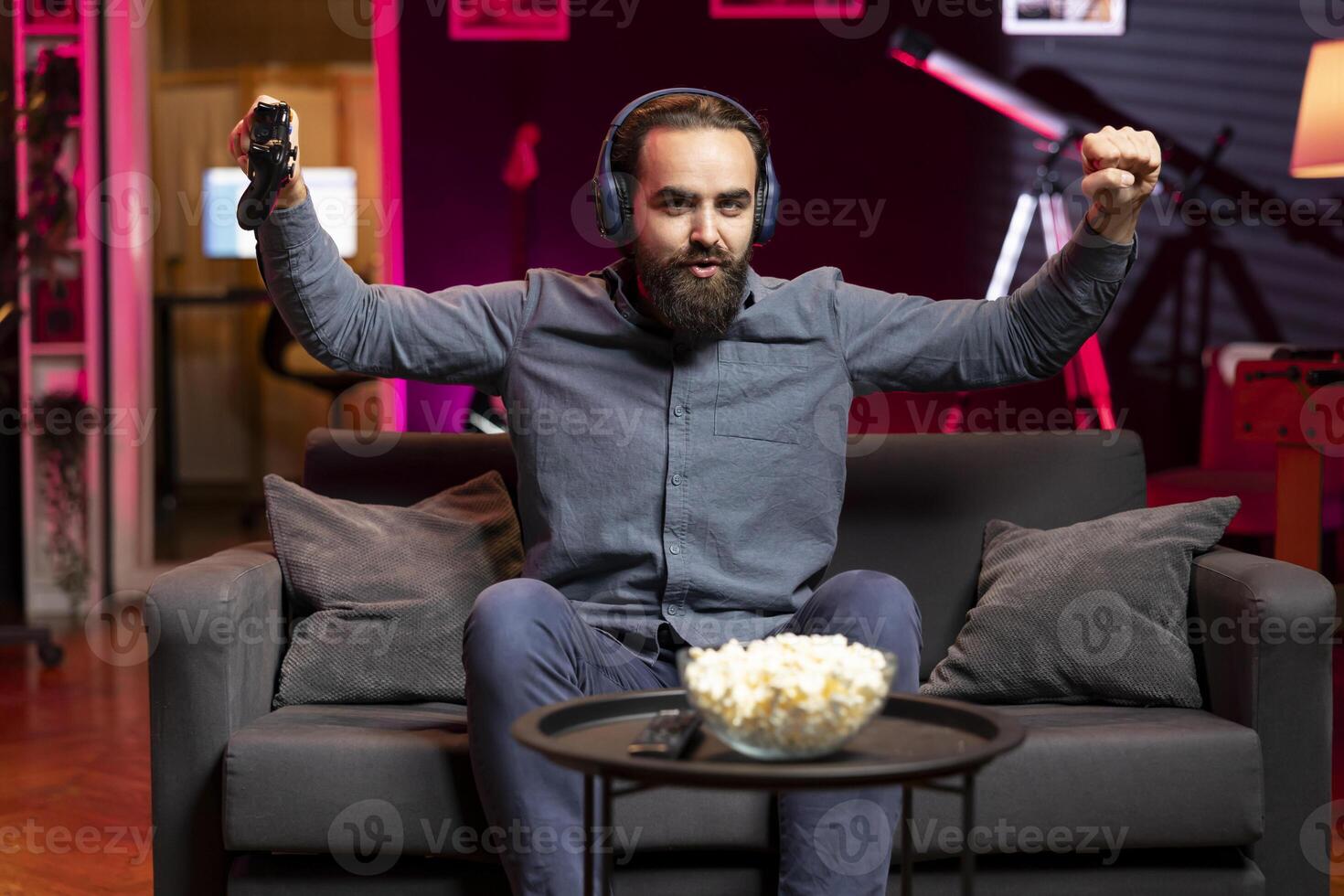 Cheerful gamer bragging after finally defeating all enemies while playing on gaming console. Joyful player congratulating himself after winning videogame using controller photo