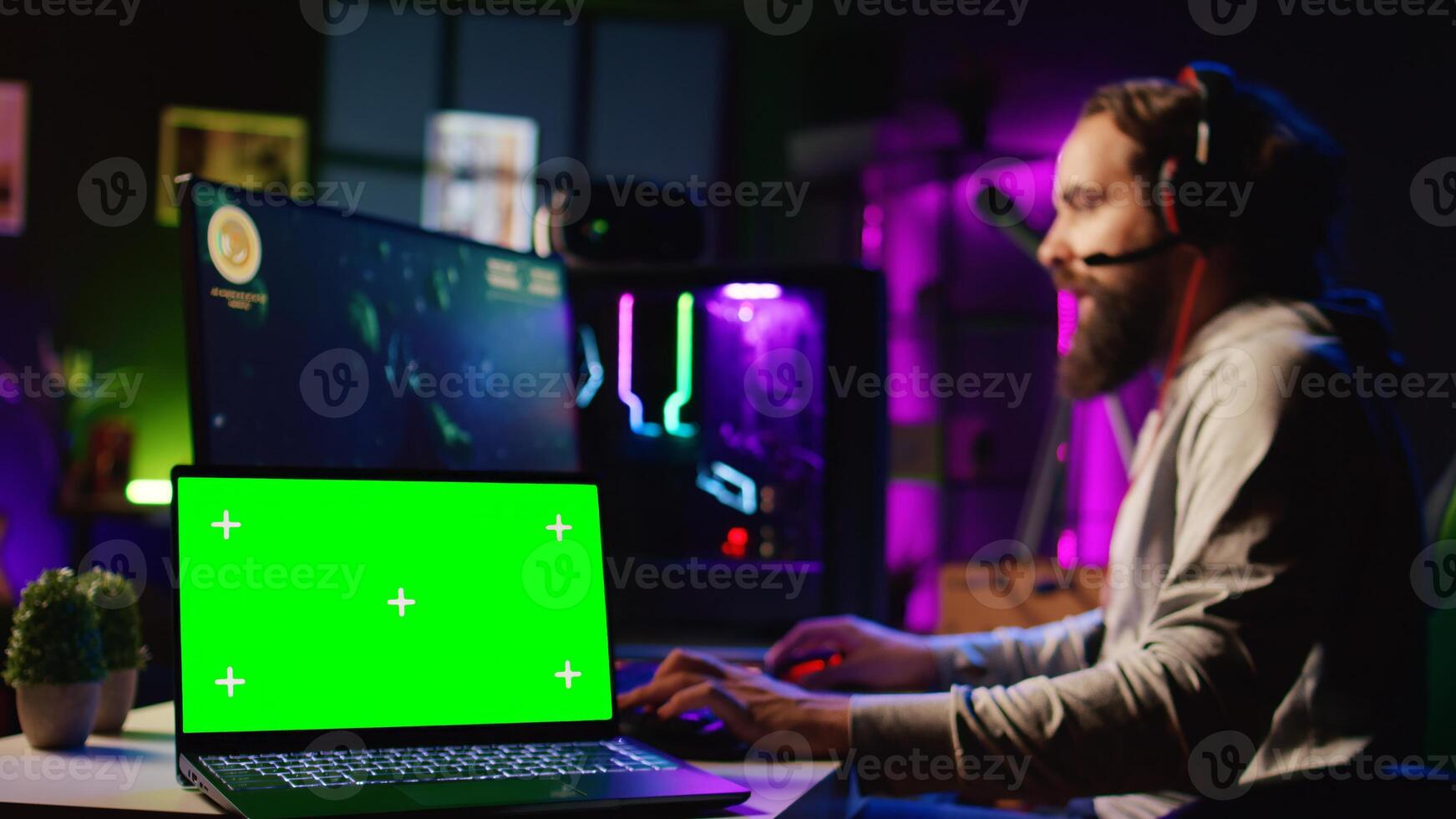 Chroma key laptop next to man playing high FPS singleplayer videogame with spaceship shooting lasers. Isolated screen notebook near gamer using crosshair to hit targets in SF game, zoom out photo