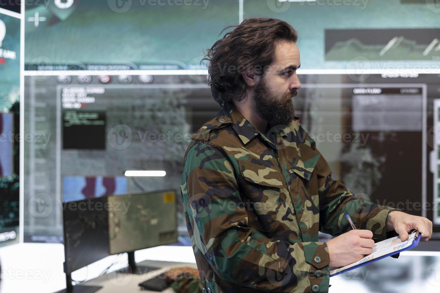 Special operations officer allocating resources based on mission needs, examining strategic data infographics on papers. Military specialist does research for battlefield signal support systems. photo