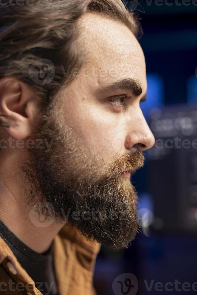 Focus on developer typing code on computer in blurry background to futureproof company network from downtimes and unexpected system failures, increasing data security, close up shot on face photo