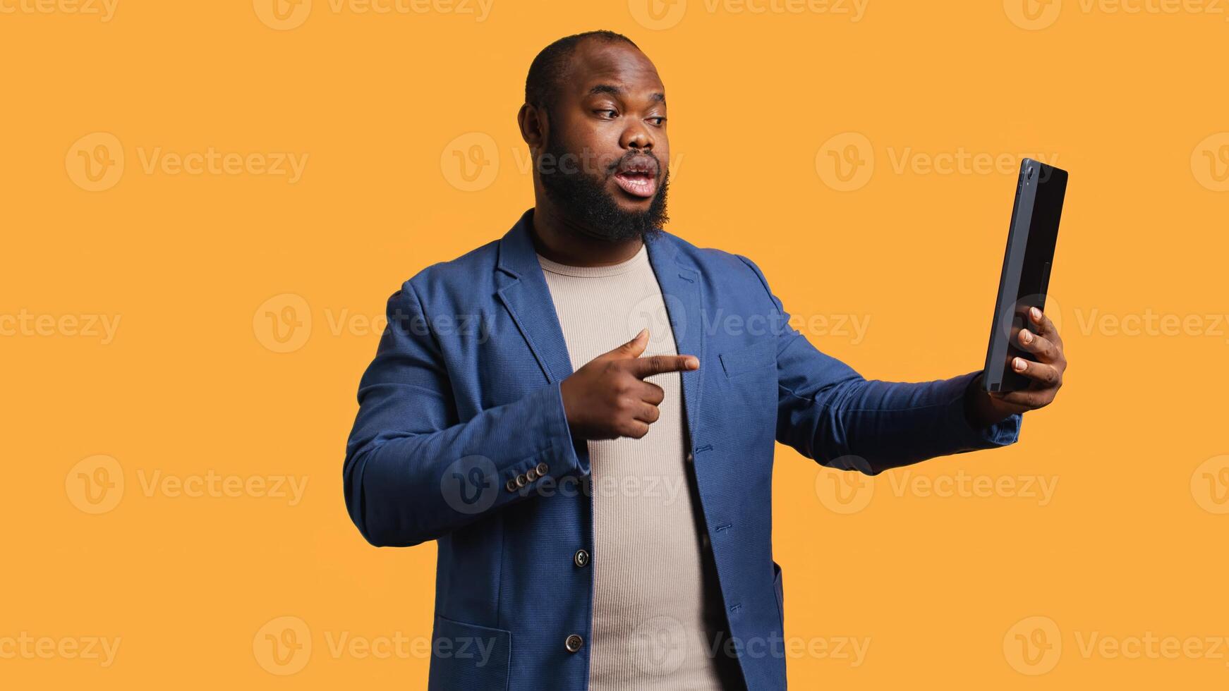 Joyful man having entertaining conversation with friends during teleconference meeting using tablet, studio background. Happy person having fun interacting with mates during online videocall, camera B photo