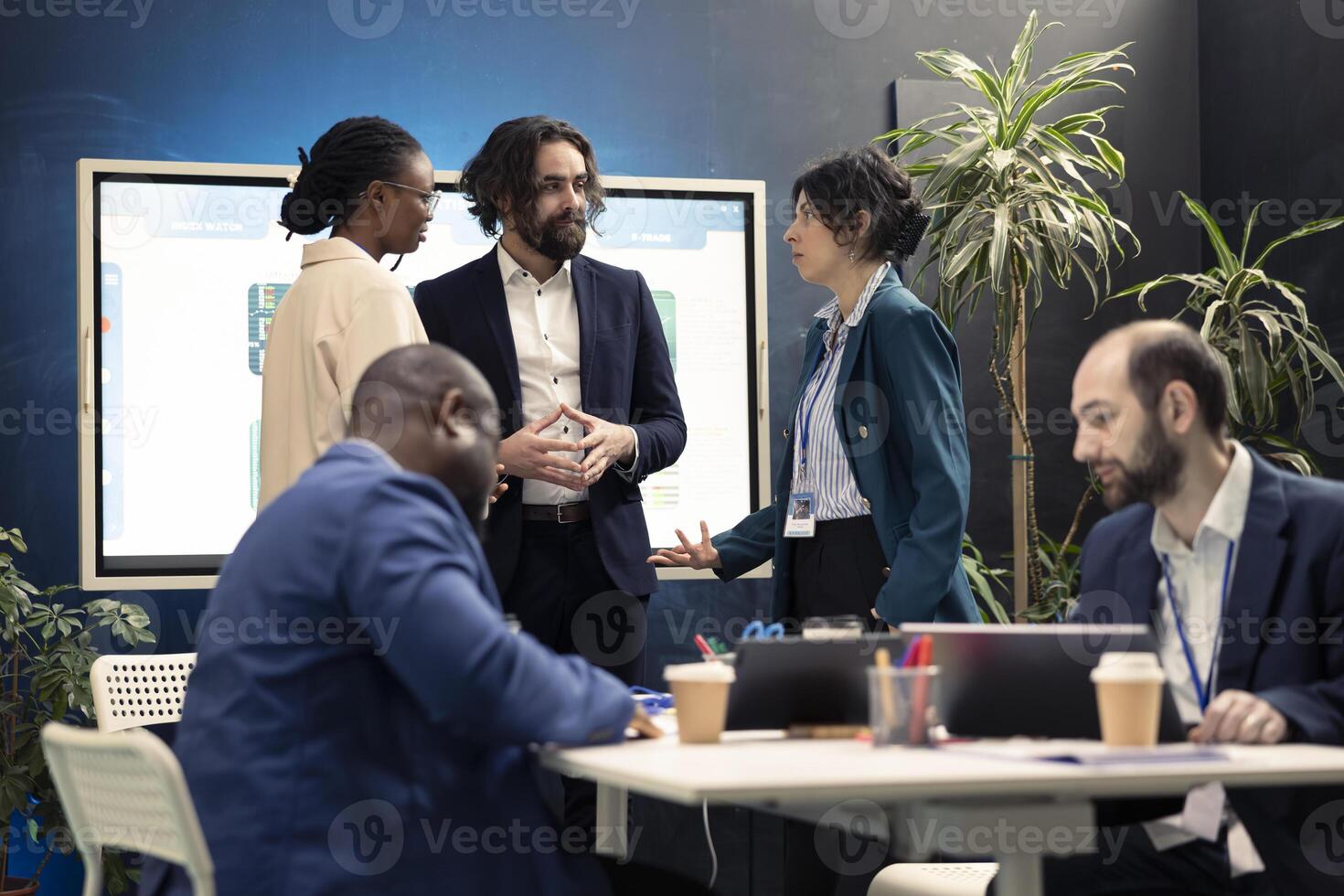 Team members from a business enterprise discussing insight of new project during a corporation meeting. Diverse coworkers stay informed about industry developments and legal decrees. photo
