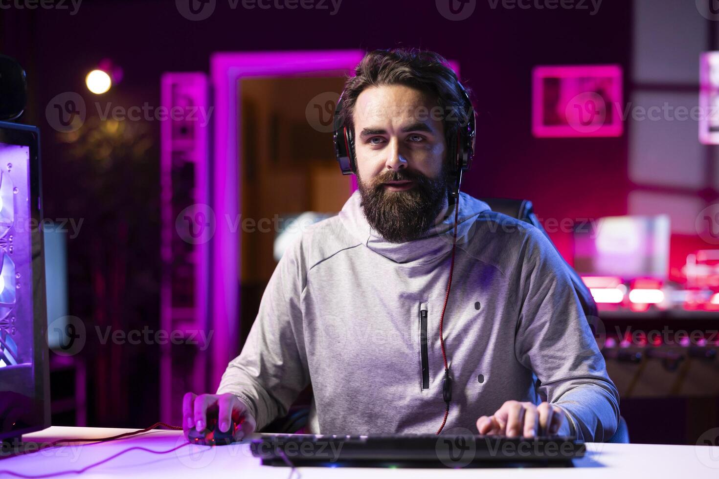 Person using headphones microphone to talk with teammates while playing FPS videogame with gun shooting laser bullets. Gamer chatting with internet friends while enjoying SF game, having fun photo