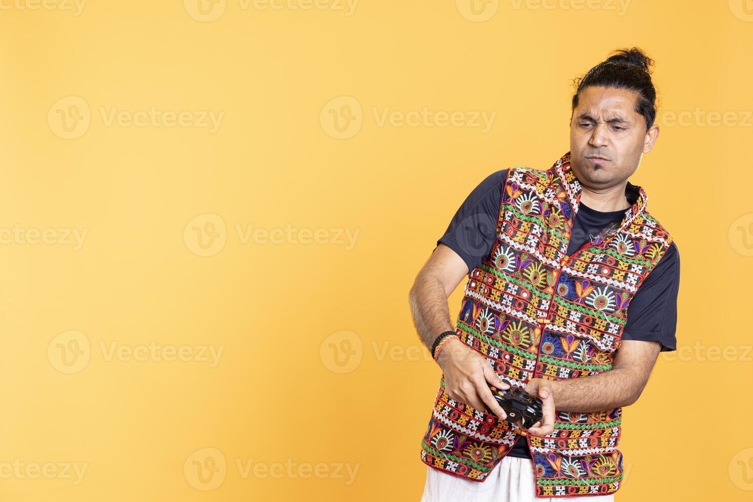 Gamer saddened by loss while playing singleplayer videogame, being defeated by rival players. Unhappy man disheartened after seeing game over message, holding controller, studio background photo