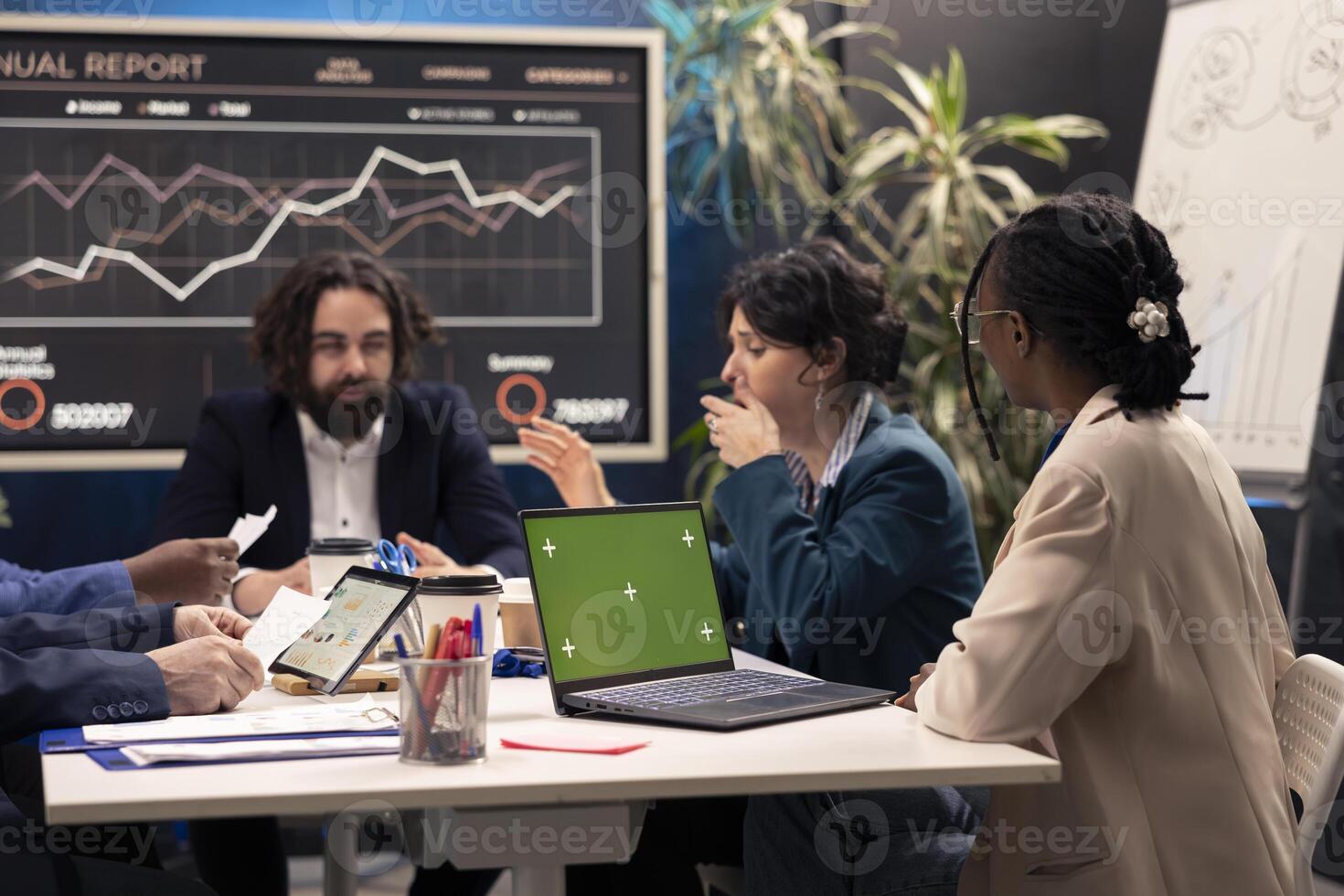 Business associates attending conference next to greenscreen laptop, deciding the fate of the global organization and working on developing resources. Operations team addressing daily issues. photo