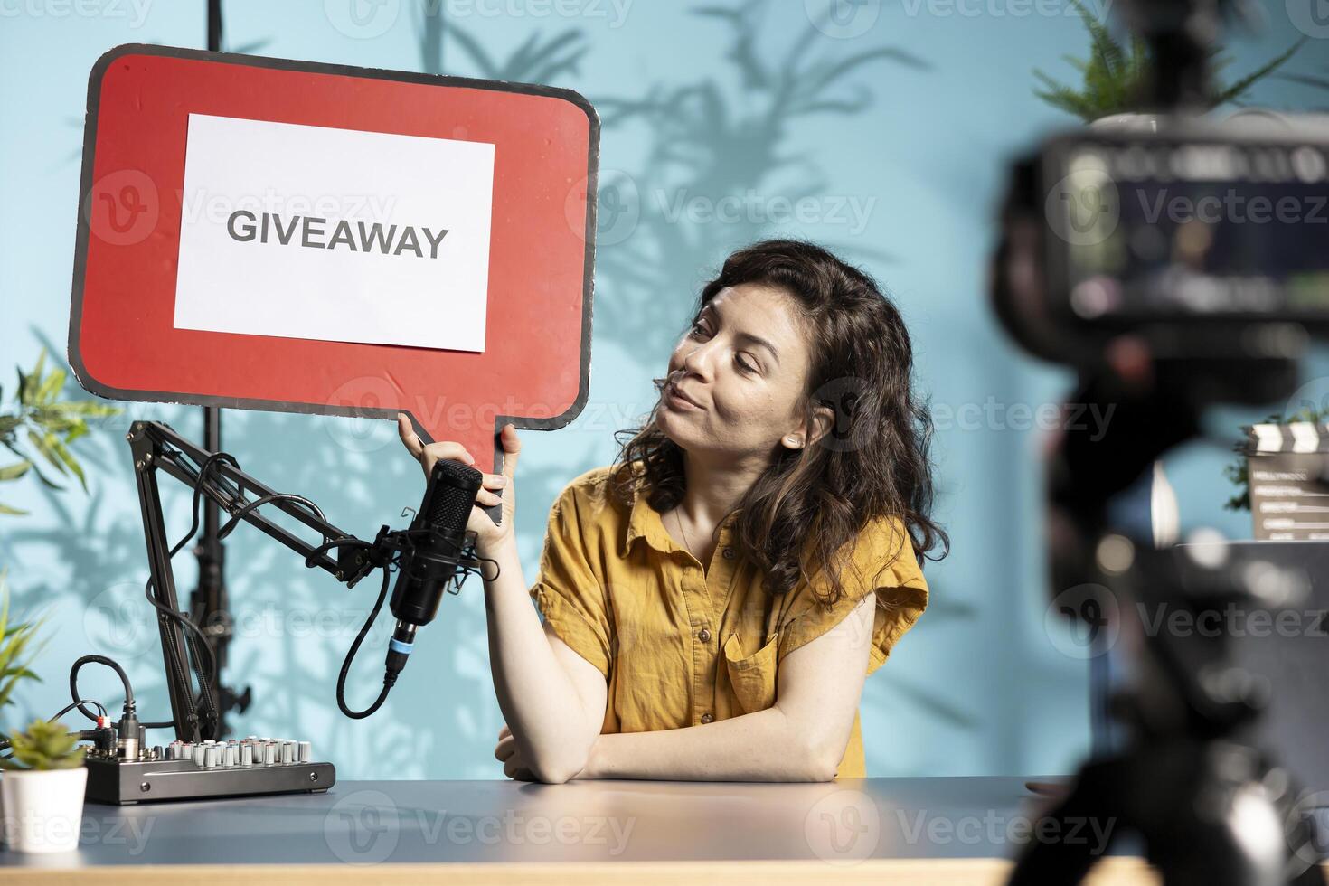 Influencer filming sponsored content, holding copy space sign advertising giveaway, talking to audience. Internet star using cardboard bubble speech cutout to do content promotion to viewers photo