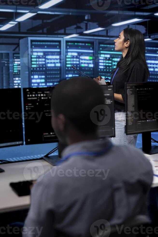 Manager in server hub using computer to find firewall misconfigurations affecting rackmounts performance. Supervisor checking systems bottlenecks leading to sluggish data transfer rates photo