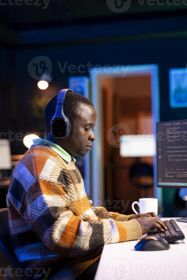 Male programmer working on developing new html script, typing binary code on terminal window. Young web developer does debugging work with coding language, database internet security. photo