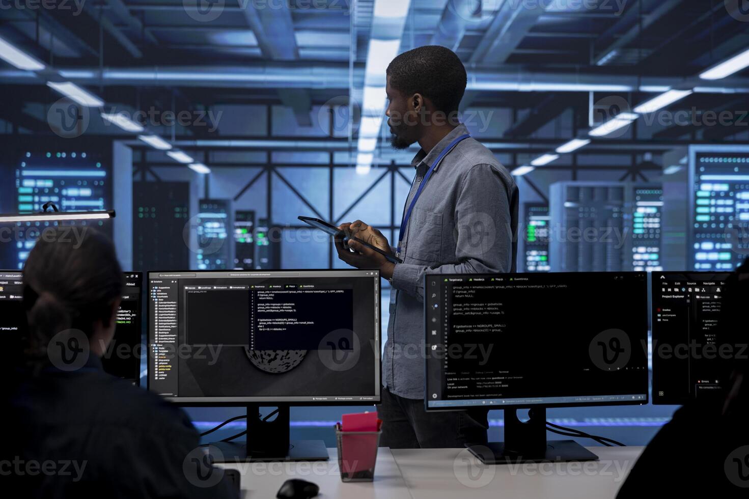 Admin in data center using tablet to check for server performance issues arising due to high CPU usage. Server room employee fixing insufficient memory errors slowing down hardware photo