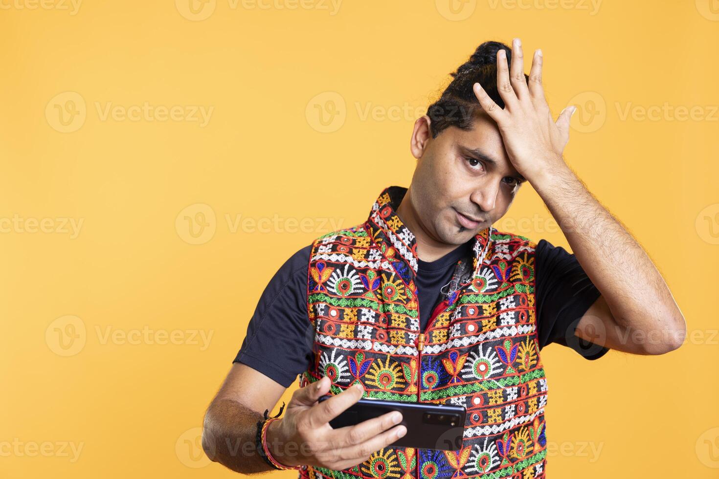 Gamer annoyed after losing online multiplayer videogame on cellphone, doing facepalm hand gesture. Player feeling frustrated after failing to win, isolated over studio background photo