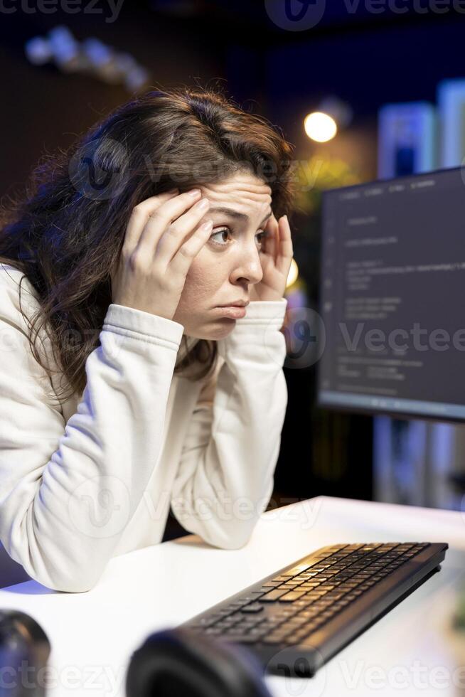 Stressed programmer rubbing temples, trying to fix vulnerabilities in software systems, suffering headache. Tired IT expert feeling pain from fatigue, using PC to patch security exposures photo