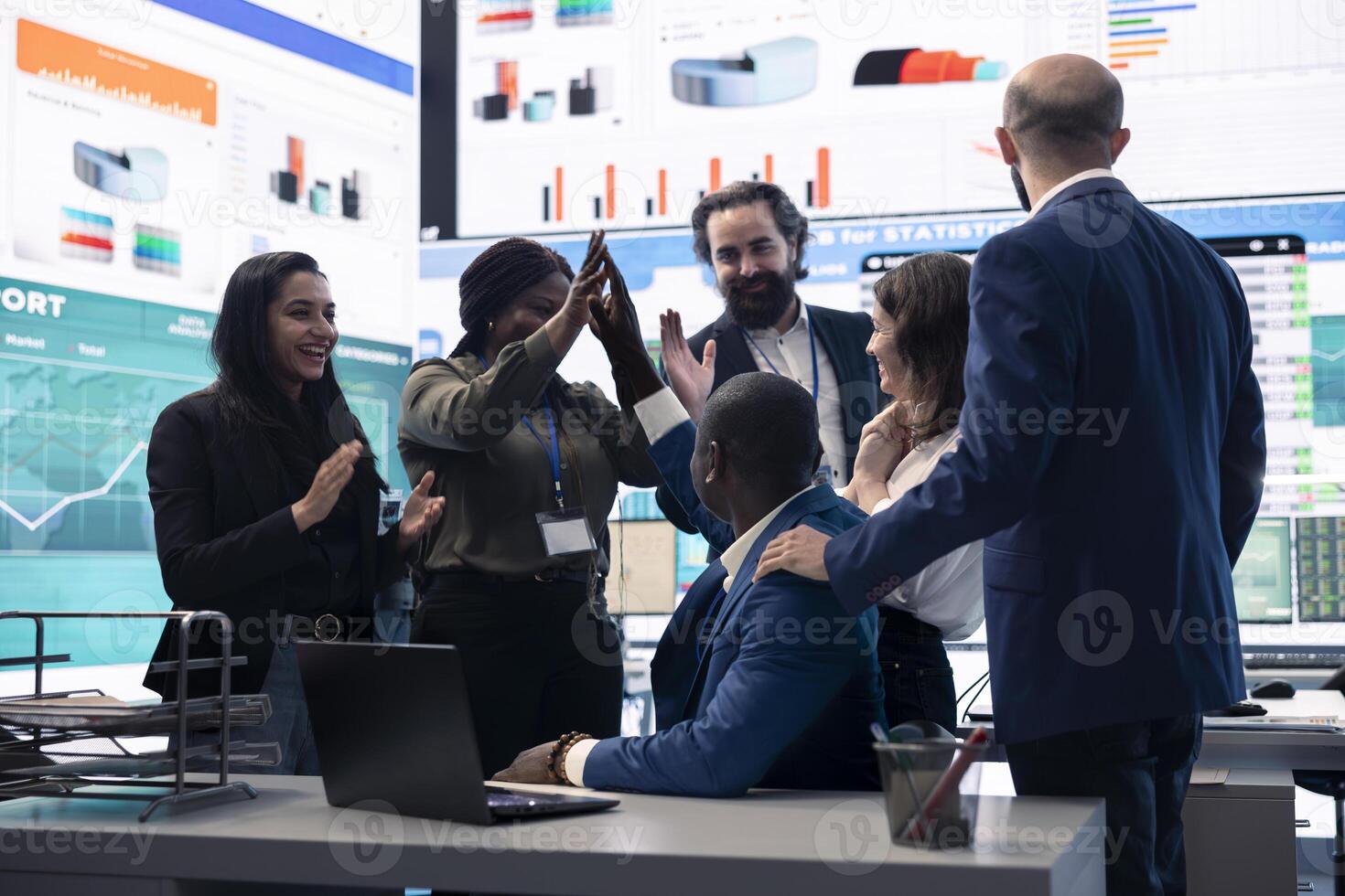 Diverse enterprise team enjoying huge global expansion progress, feeling excited about the future and celebrating a successful partnership outcome. High five between employees. photo