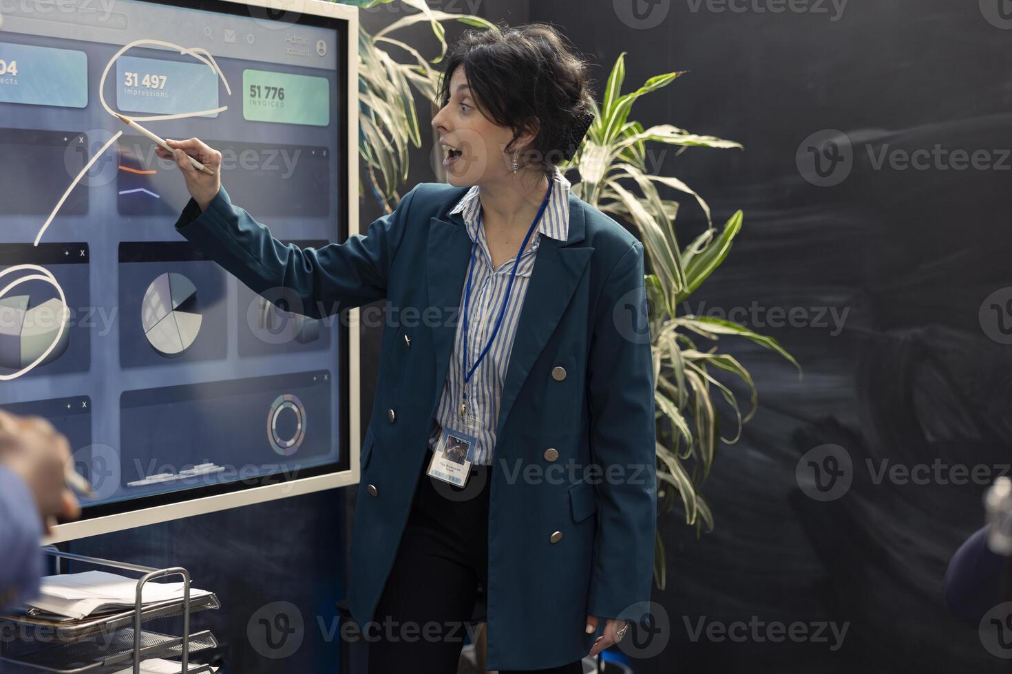 Woman consultant examining monthly sales infographics on interactive board, reviewing feedback on previous initiatives for future improvements. Management team in a conference. photo