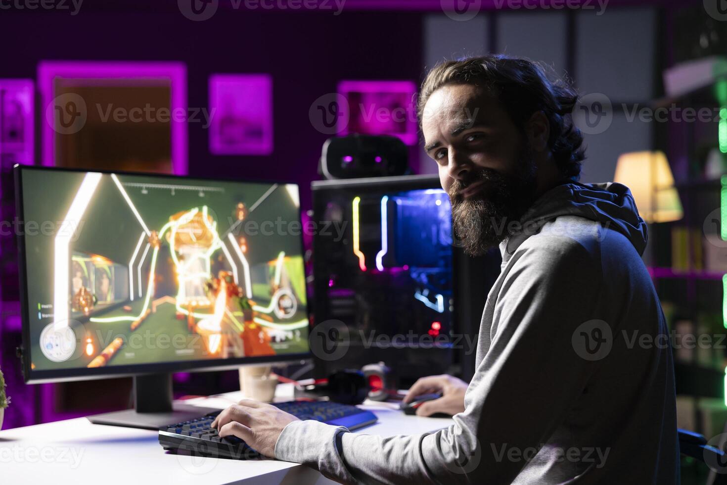 Portrait of man enjoying competitive online FPS videogame, battling flying robots with his friends. Smiling gamer talking with internet teammates while playing first person shooter game, fighting boss photo