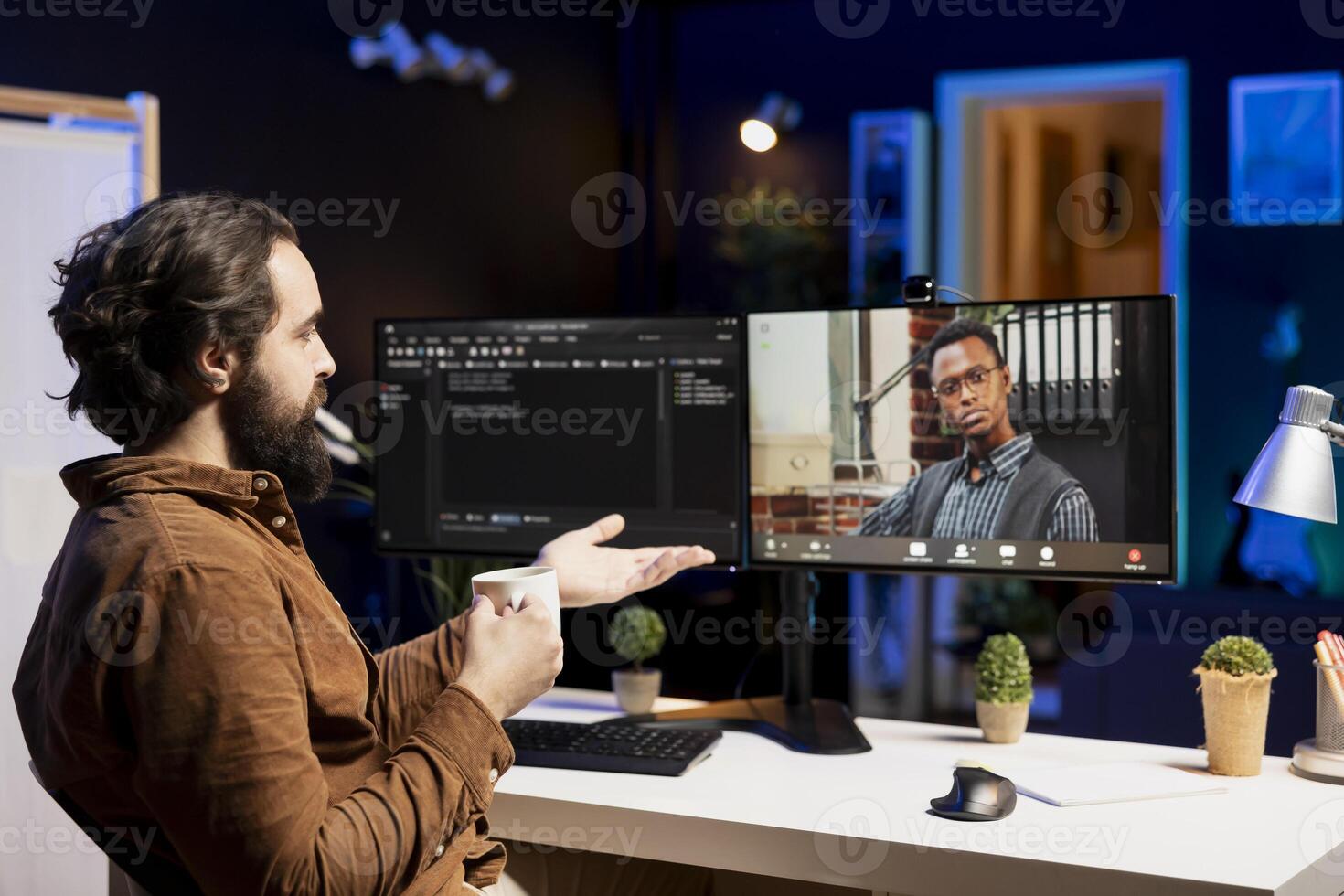 IT developer working from home in remote videocall with BIPOC coworker, testing programs and systems. Programmer checking code with colleague in internet videoconference meeting photo
