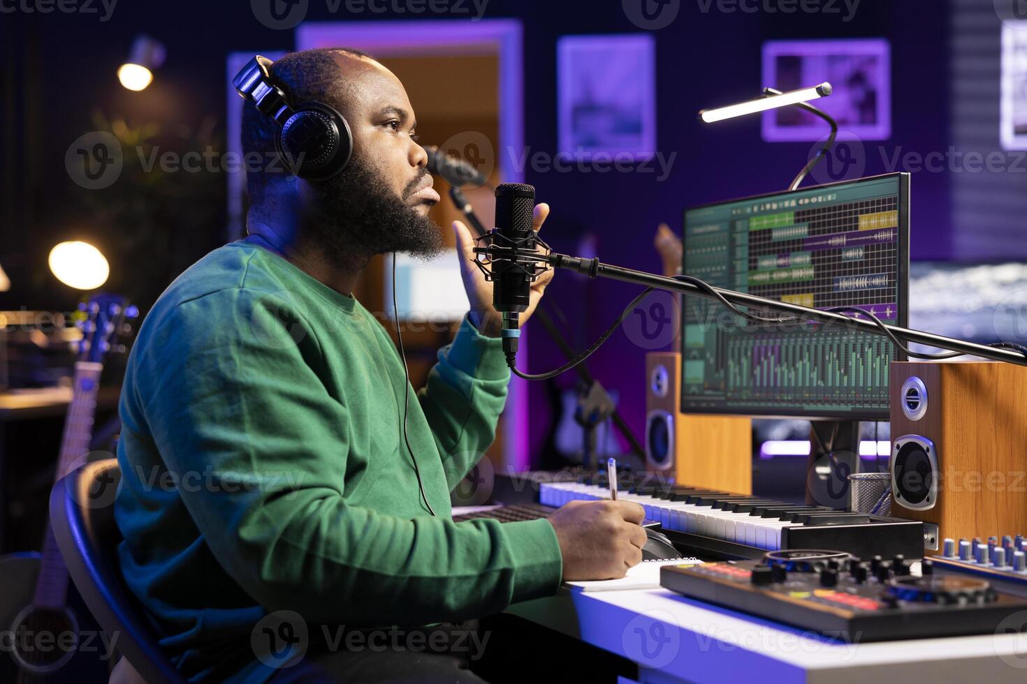 Musician artist thinking about new verses to fit the rhymes of the song, writing lyrics to produce a track in his home studio. Professional singer making music for his debut album. photo