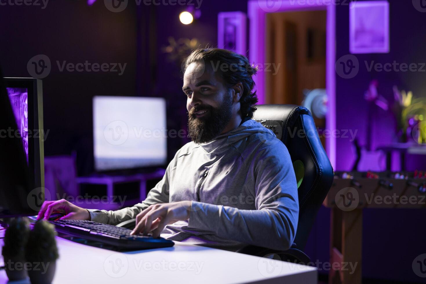 Smiling man plays online multiplayer videogame with friends, feeling happy. Cheerful player talking with teammates, enjoying leisure time, controlling character, finishing missions photo