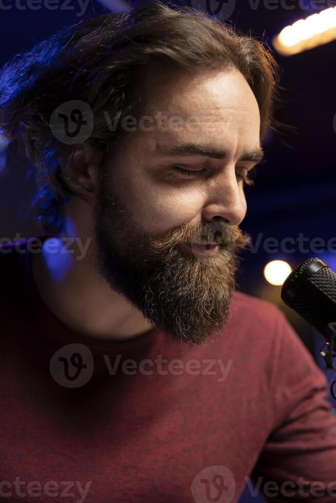 Songwriter composing new music and singing on microphone, playing piano keyboard and recording song for mixing and mastering session. Artist using audio equipment in home studio. Close up. photo