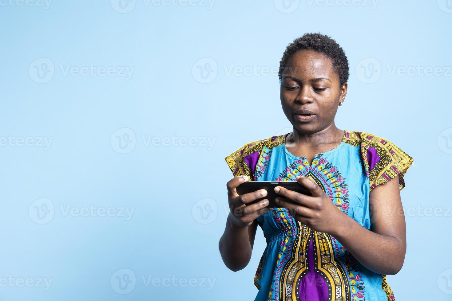 African american model playing online cyber sport competition, having fun with gaming tournament on smartphone app. Woman enjoying mobile games play, virtual championship. photo