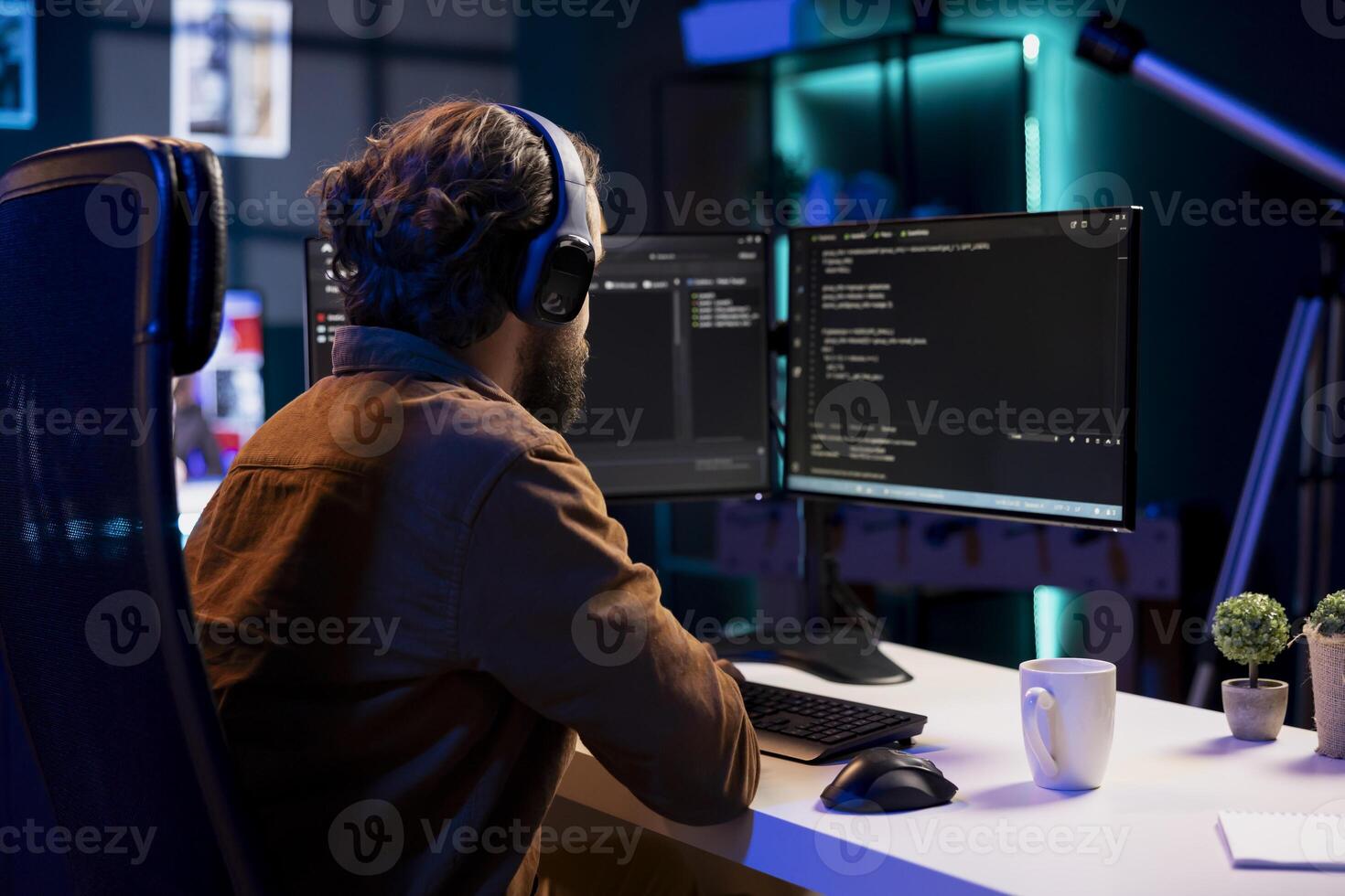 Man listening music while doing software quality assurance, reading source code on computer screen. Developer wearing headphones enjoying podcasts and inspecting coding on desktop PC photo