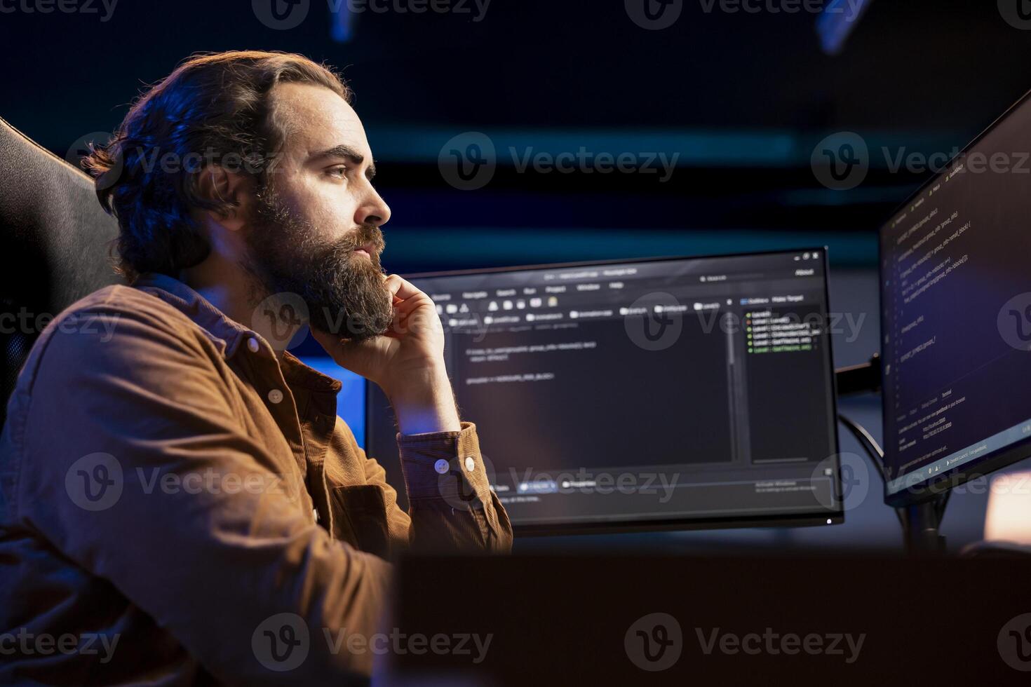Computer scientist working from home developing software in JavaScript programming language. System administrator in living room inspecting lines of code on desktop PC monitor photo
