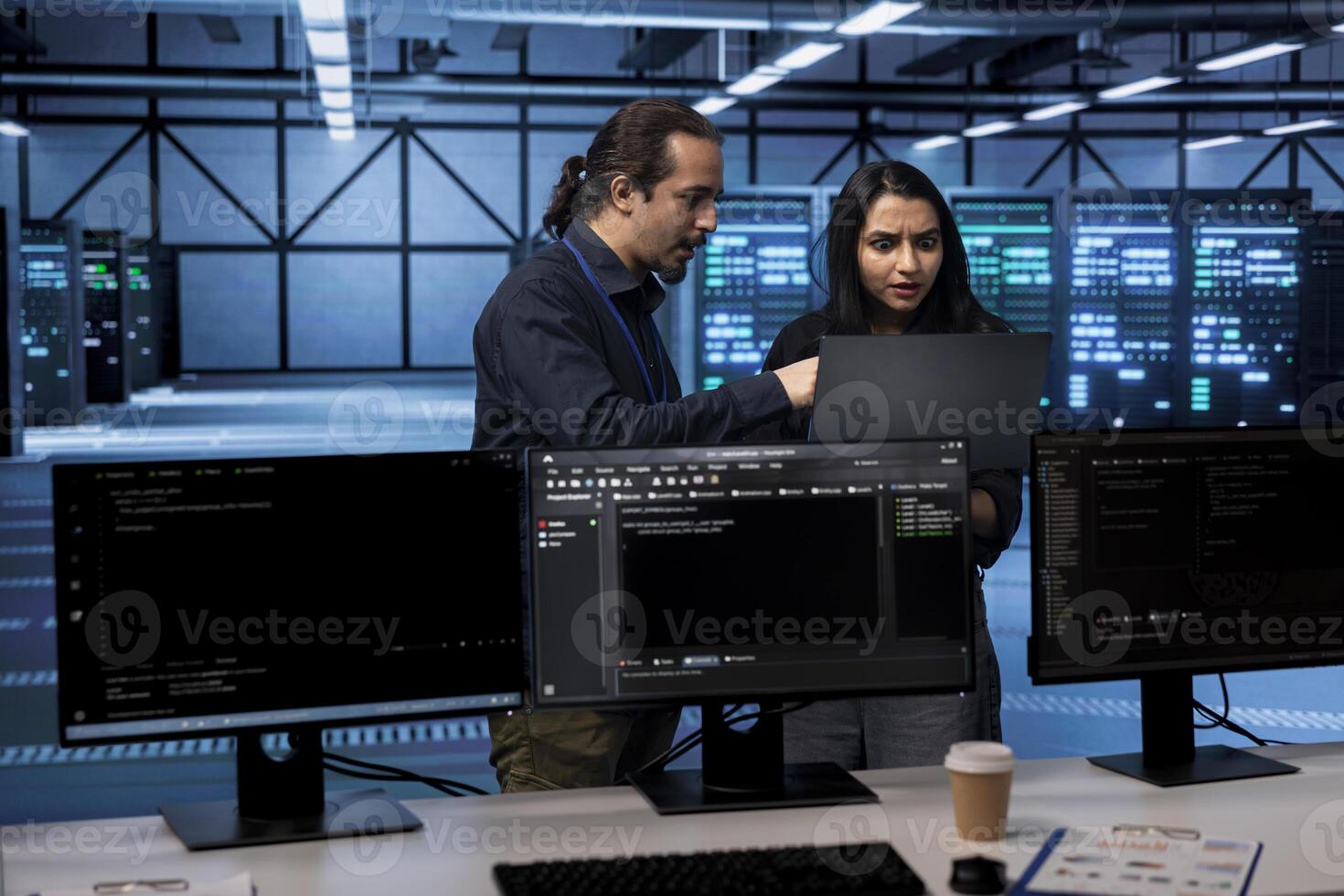 Coworkers in server hub establishment confused by errors on laptop screen. Perplexed admins shocked by system bugs while safeguarding data center equipment against malware photo
