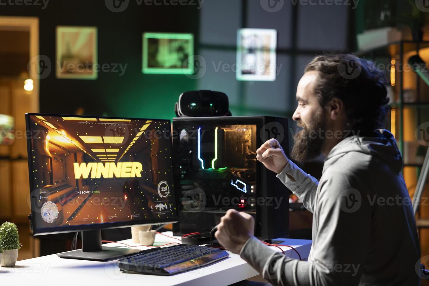 Happy man celebrating after completing videogame in neon lit living room. Smiling gamer having gaming session, ecstatic about victory while competing in multiplayer tournaments photo