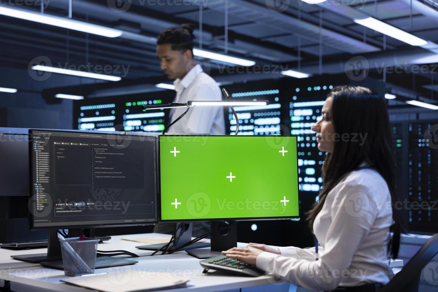 Developer coworkers using mockup laptop to check server clusters configuration settings. Specialists checking event logs in monitoring software on chroma key notebook in data center photo