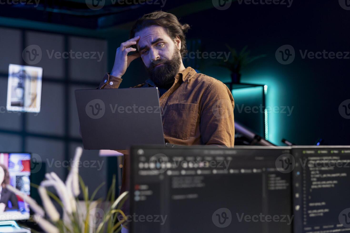 Programmer scratching head in confusion trying to secure company servers from virus attacks. Hesitant IT remote employee unsure how to fix code, trying to building firewalls protecting data photo