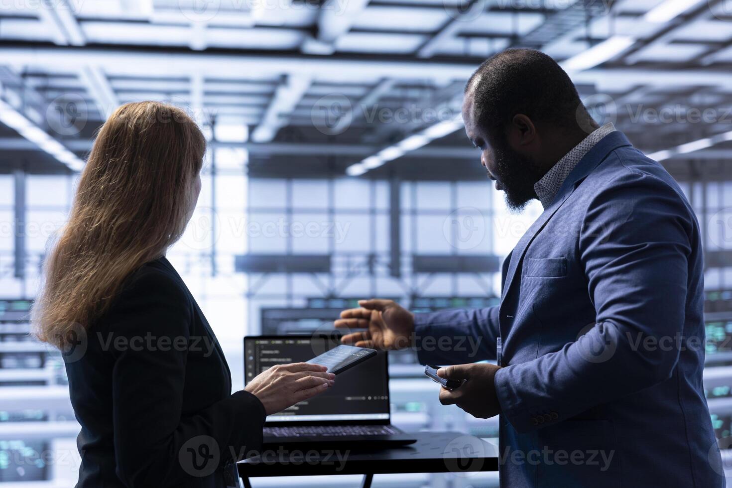 Admin and manager doing disaster recovery planning and security protocol enforcement in data center. Coworkers doing brainstorming in server room to reduce downtime, ensuring business continuity photo