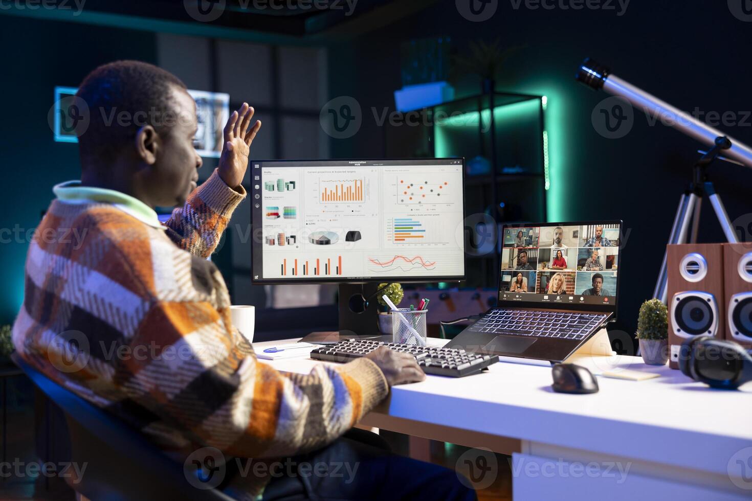 African american man talking on call using personal computer, discussing about accounting infographics. Young adult communicating online and examining monthly revenue balance. photo
